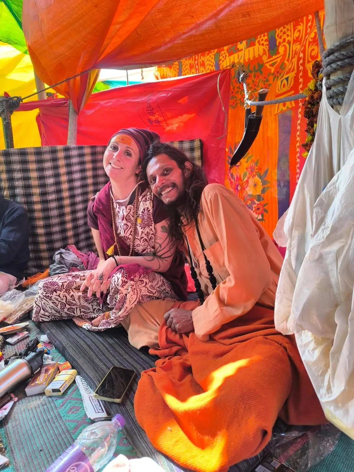 Laura Buoncristiani sorride accanto a un sadhu sotto una tenda colorata