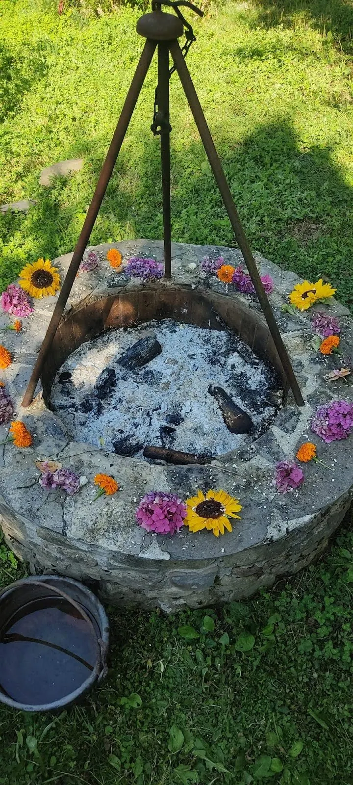Il braciere di pietra nel prato con una corona di fiori, pronto per il fuoco