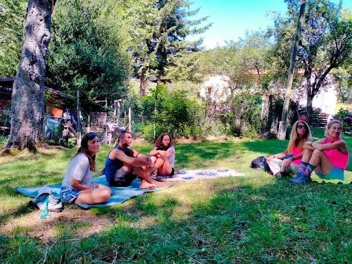 Il gruppo seduto sui teli nel prato, all'ombra degli alberi