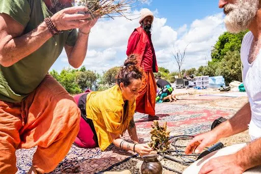 Un rito all'aperto in India: mani che preparano le offerte su un tappeto colorato