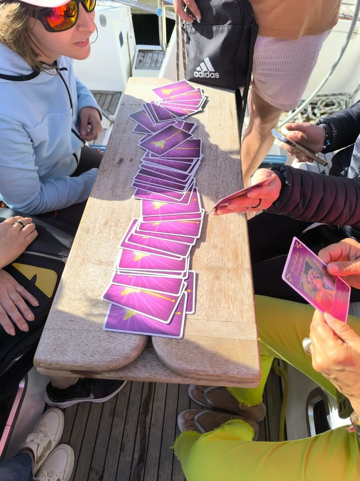 Le carte disposte in fila su una tavola di legno, fra le mani delle partecipanti
