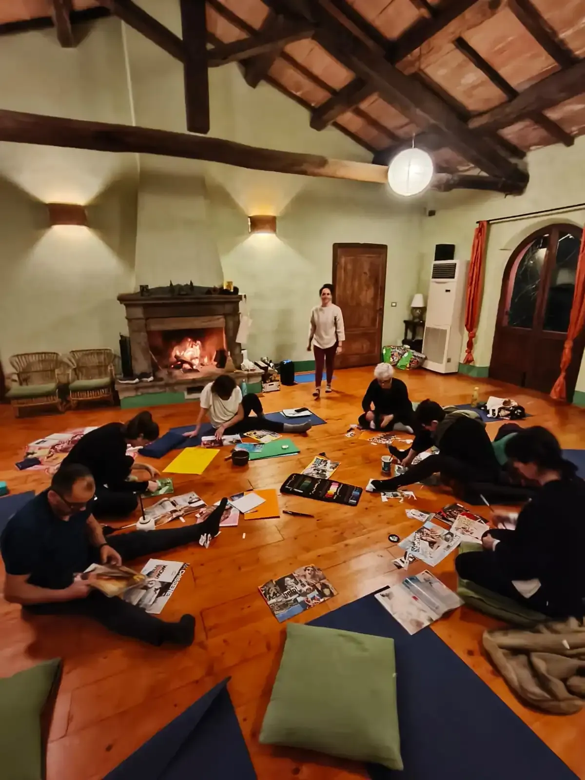 Il gruppo seduto in cerchio sui tappetini, nella grande sala con il camino acceso e il soffitto di travi
