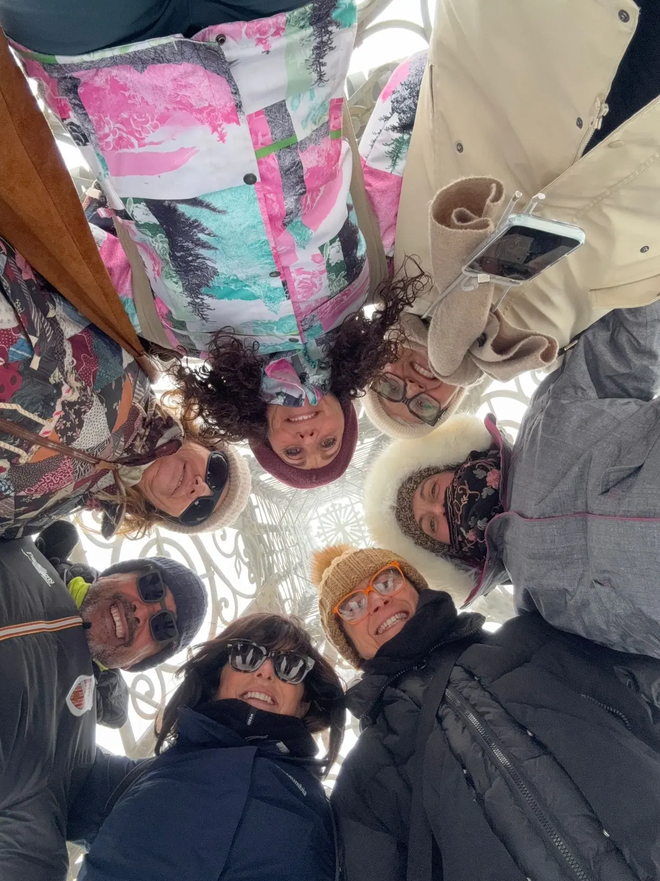 Il gruppo abbracciato in cerchio, fotografato dal basso con il cielo d'inverno