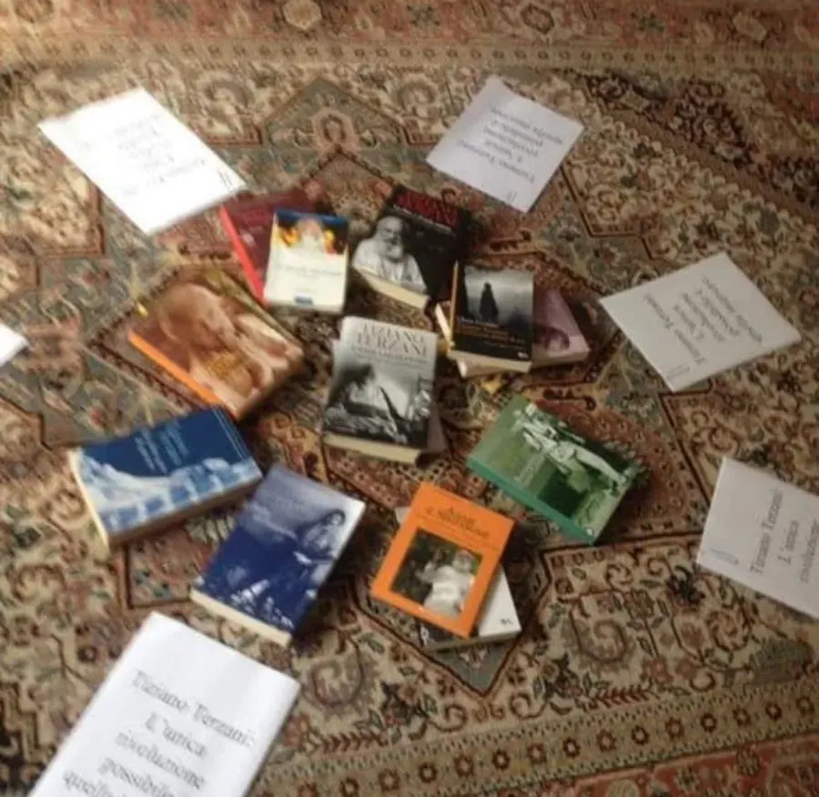 I libri di Tiziano Terzani sparsi su un tappeto, con biglietti scritti a mano
