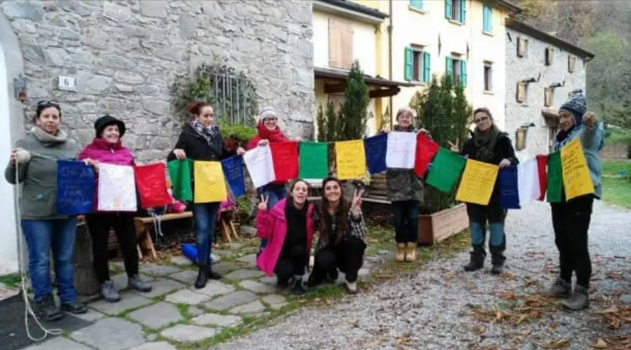 Il gruppo con le bandierine di preghiera colorate davanti alle case di pietra