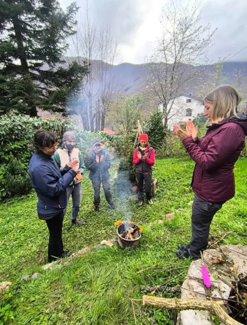 Un piccolo fuoco acceso nel prato e il gruppo in piedi in cerchio intorno