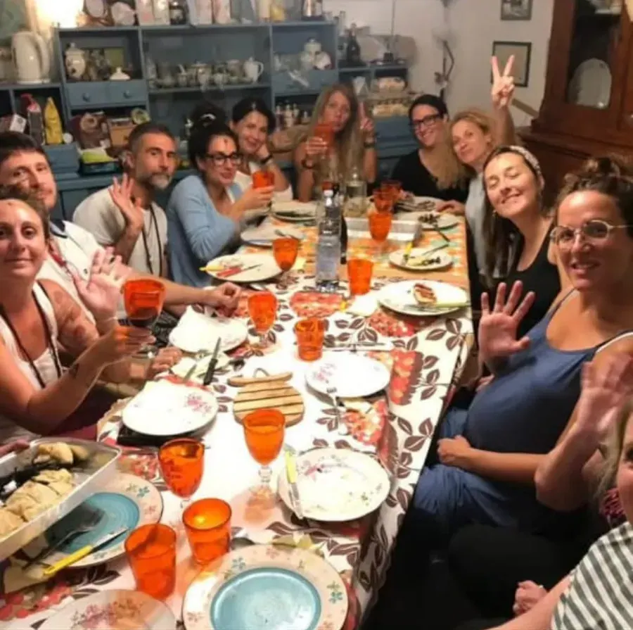 Una cena allegra intorno a una lunga tavola apparecchiata